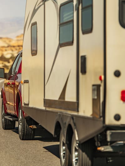 pickup truck pulling a travel trailer on a highway demonstrating how to tow a travel trailer